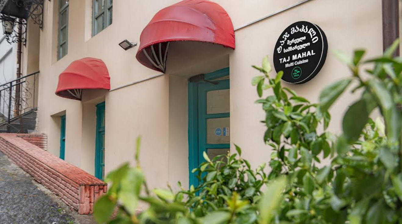 Taj Mahal Restaurant Exterior Signage - Halal certified Indian Restaurant in Tbilisi with distinctive red awnings and clear branding