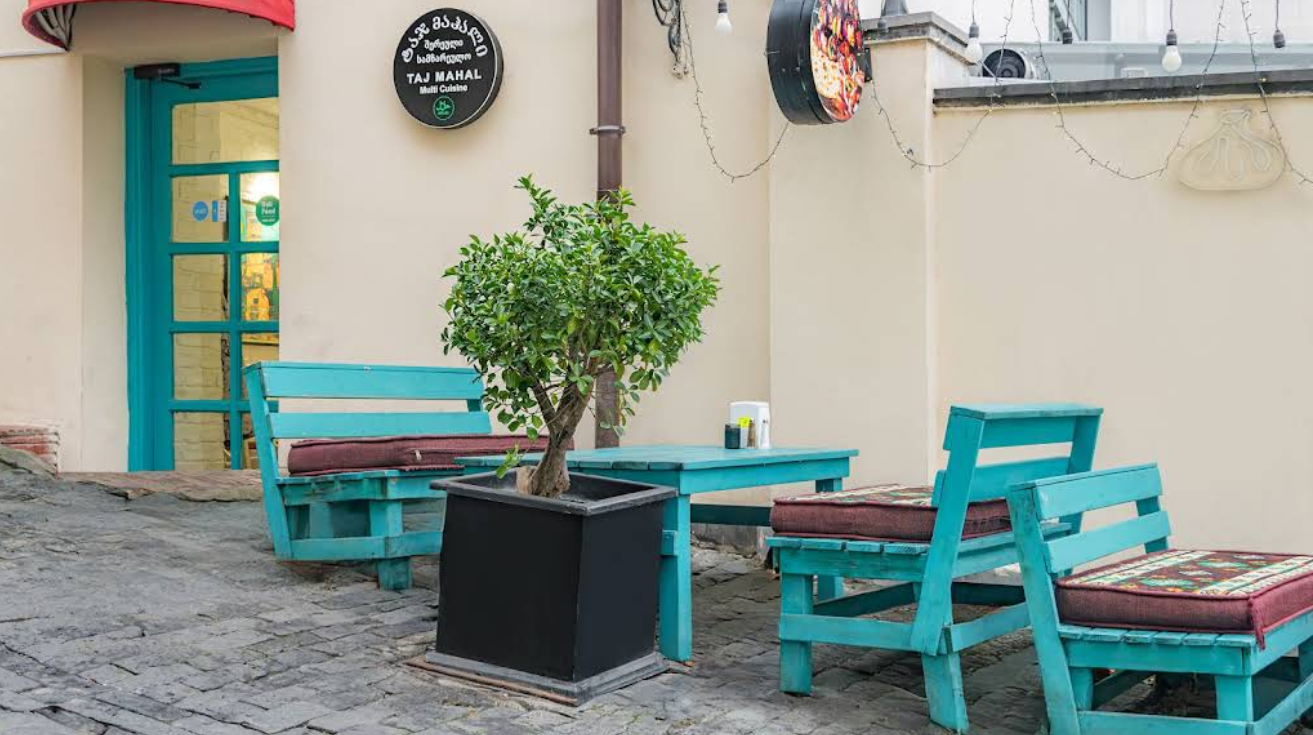Outdoor Terrace Seating - Al fresco dining at Taj Mahal Indian Restaurant in Tbilisi with turquoise furniture and cushions