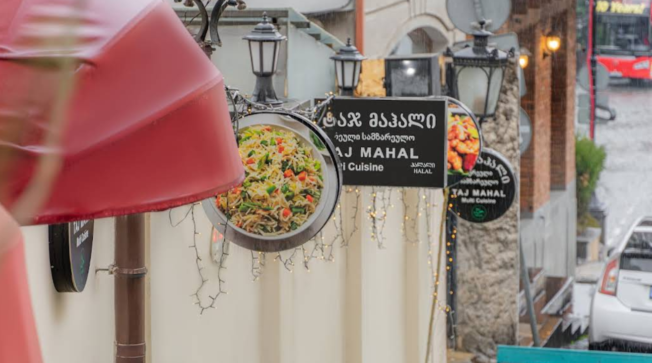 Street Signage Display - Tajmahal Restaurant Tbilisi street-level signage with authentic Indian food imagery and halal certification